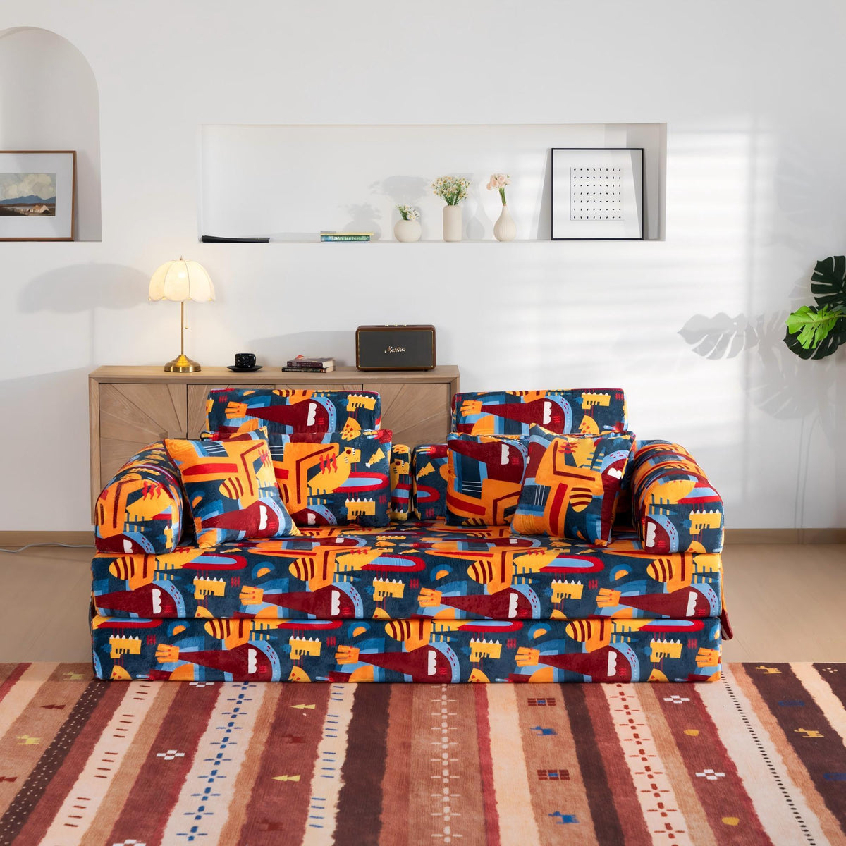 Convertible sofa bed in colorful city-pattern fabric with matching throw pillows