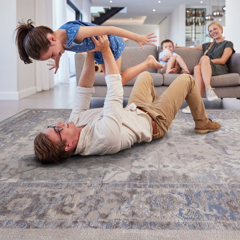 Traditional area rug with light blue-gray background and beige ornate distressed pattern.