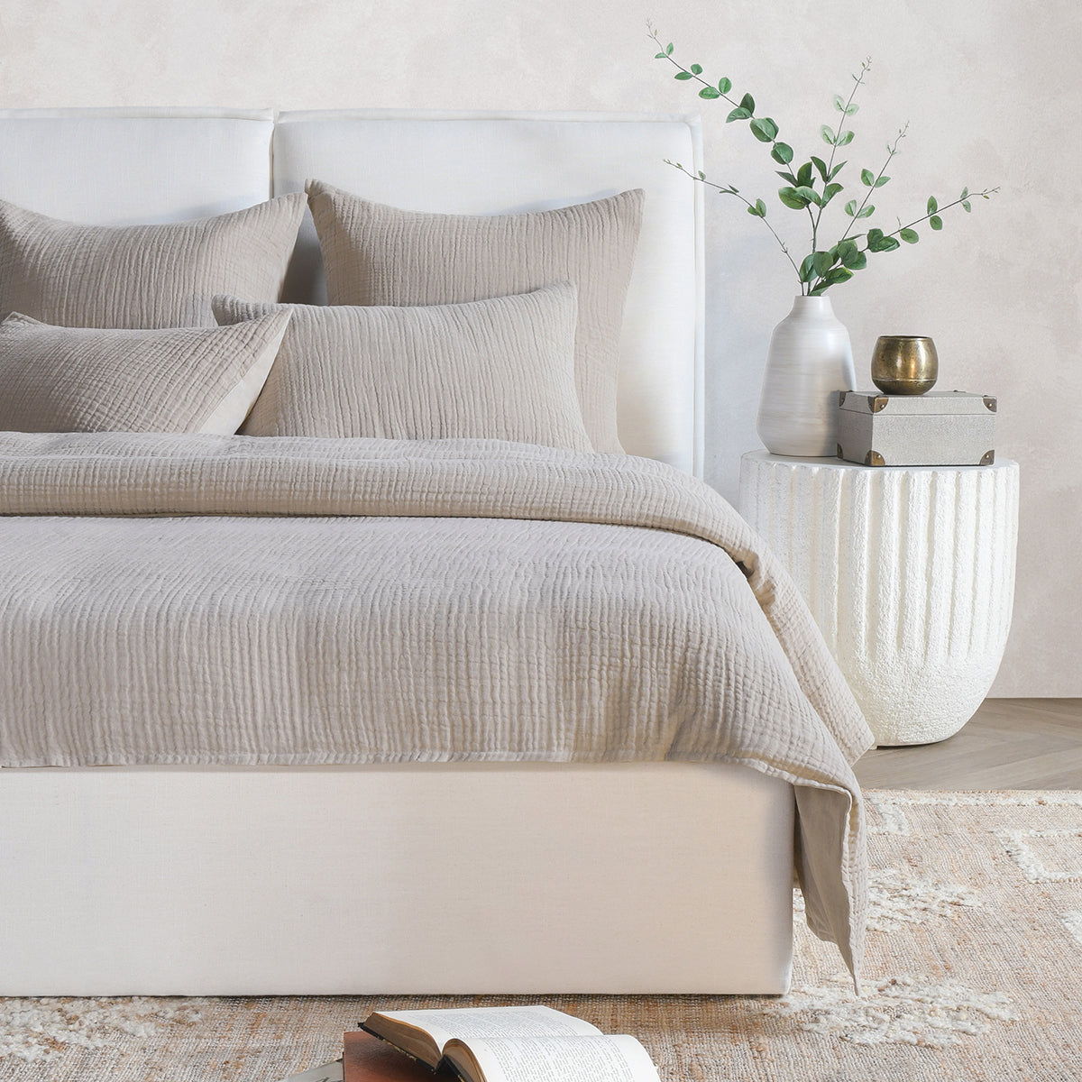 Set of light gray and cream pillow shams on a bed, textured crinkle fabric