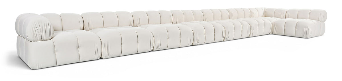 L-shaped velvet sectional sofa in white with tufted cushions and rolled arm corners