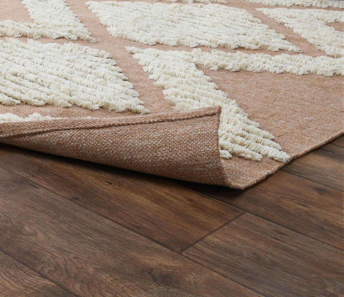 Indoor/outdoor rug corner detail with textured surface, cream and tan diamond rows