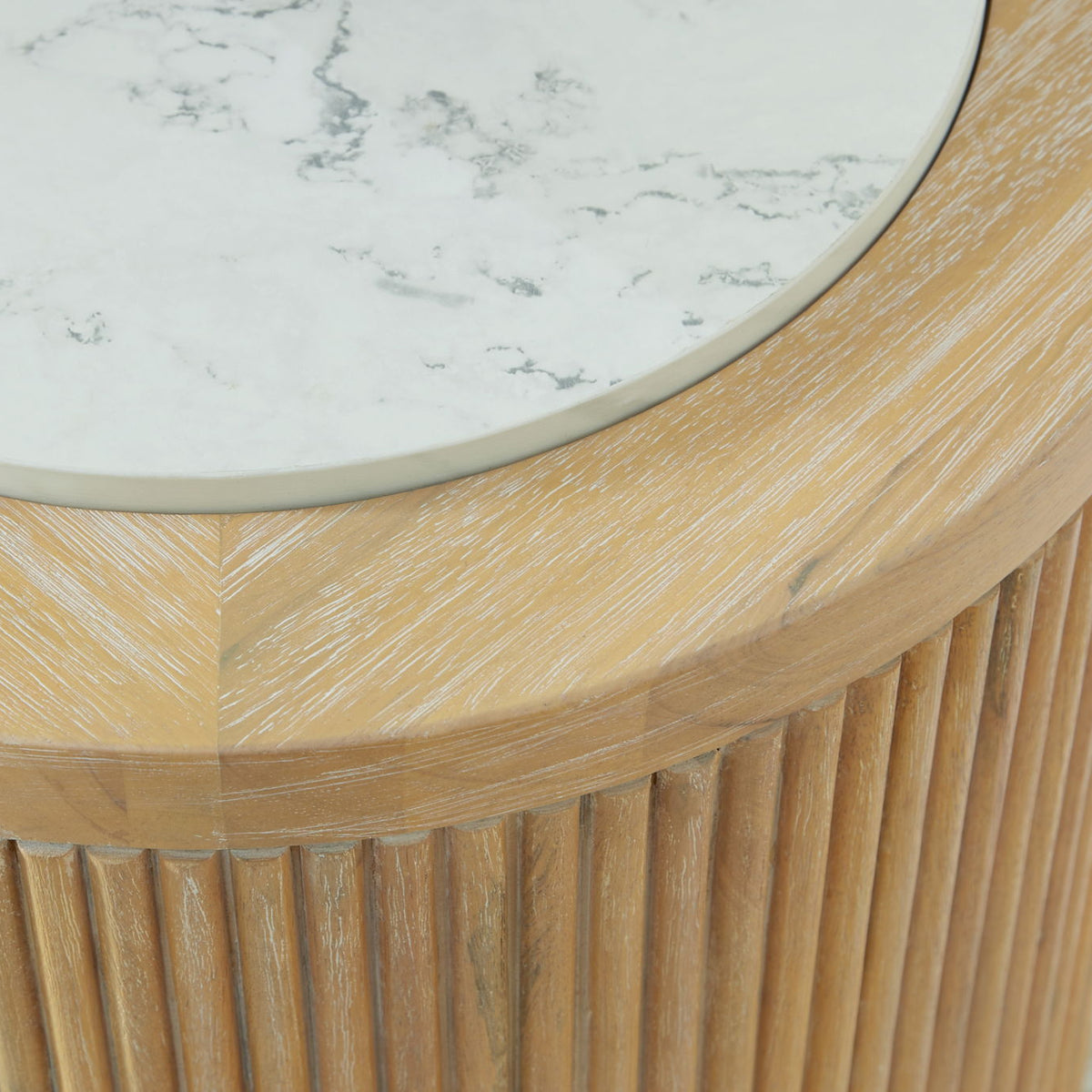 Close-up of round table edge with light wood slats and white marble surface