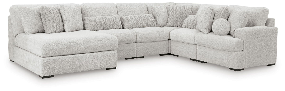 Light gray sectional corner sofa with three seat sections and textured back pillows