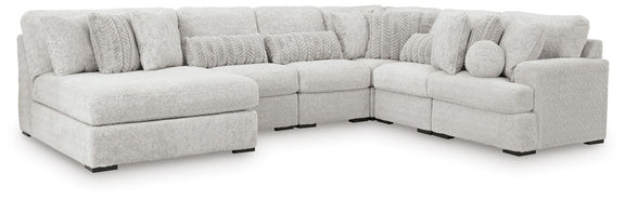 Light gray sectional corner sofa with three seat sections and textured back pillows