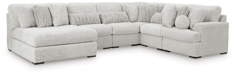 Light gray sectional corner sofa with three seat sections and textured back pillows