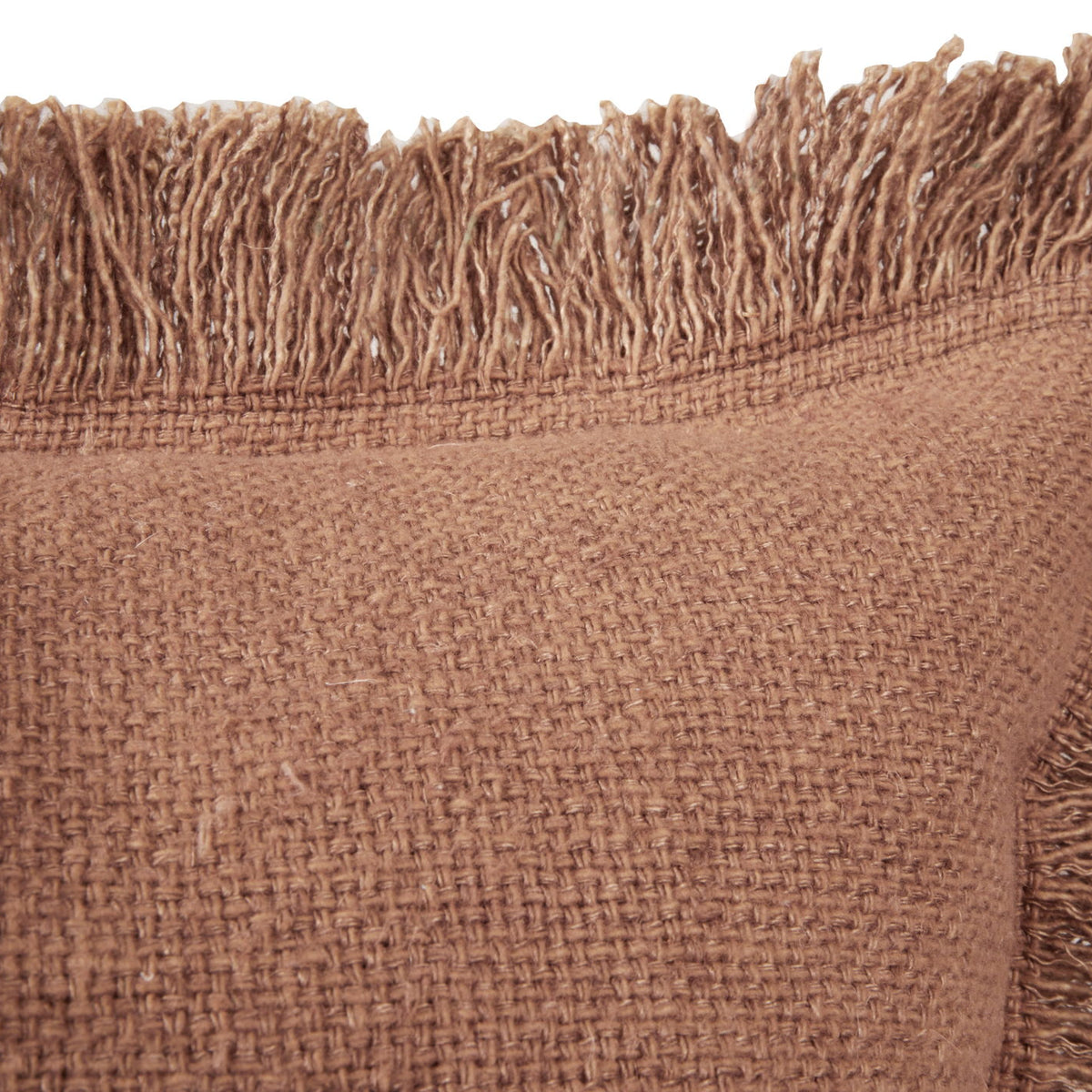 Brown square throw pillow close-up showing woven fabric and long fringe