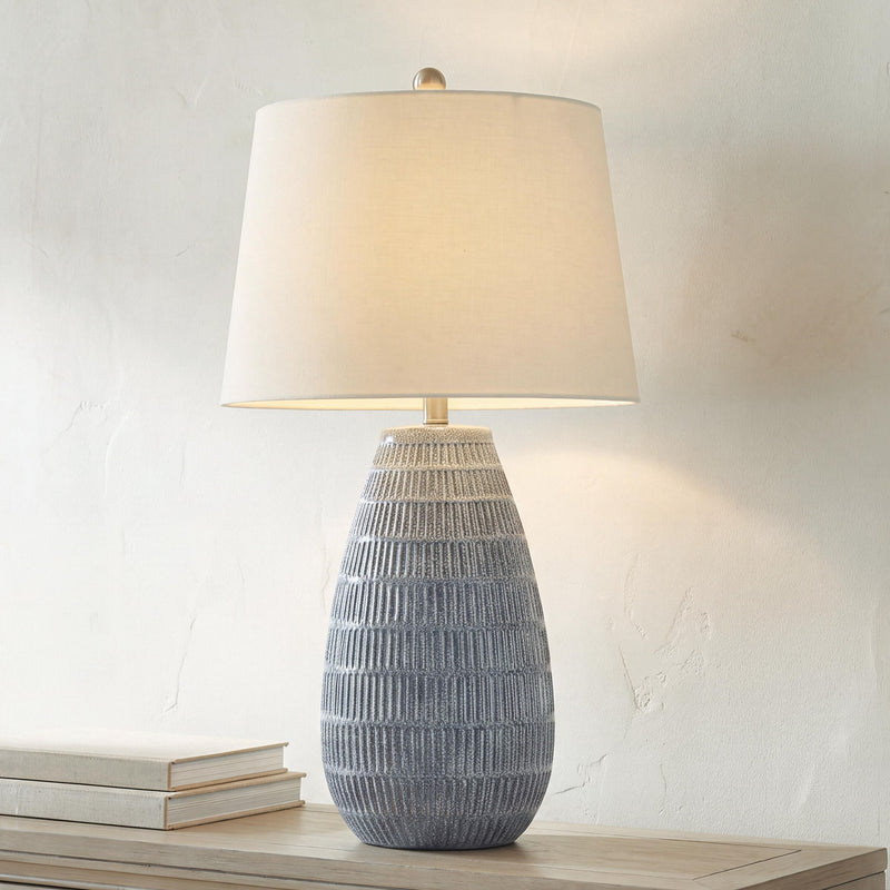 Ceramic table lamp with white drum shade and blue-gray ribbed ceramic base