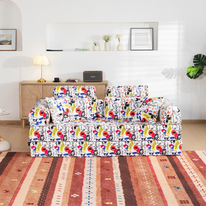 Printed convertible sleeper sofa in white with colorful graffiti pattern and throw pillows