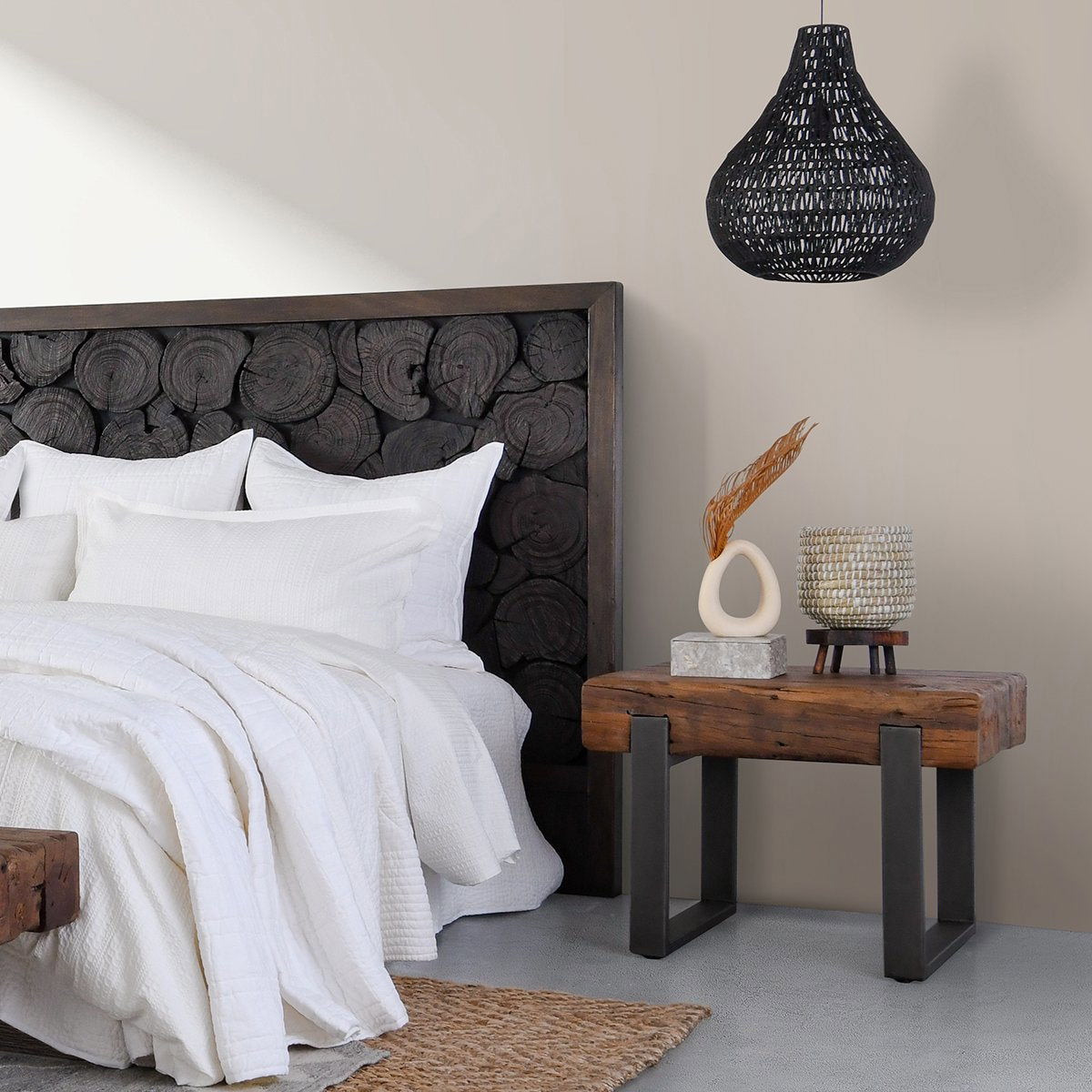 Reclaimed wood end table with black metal legs, styled with decor items