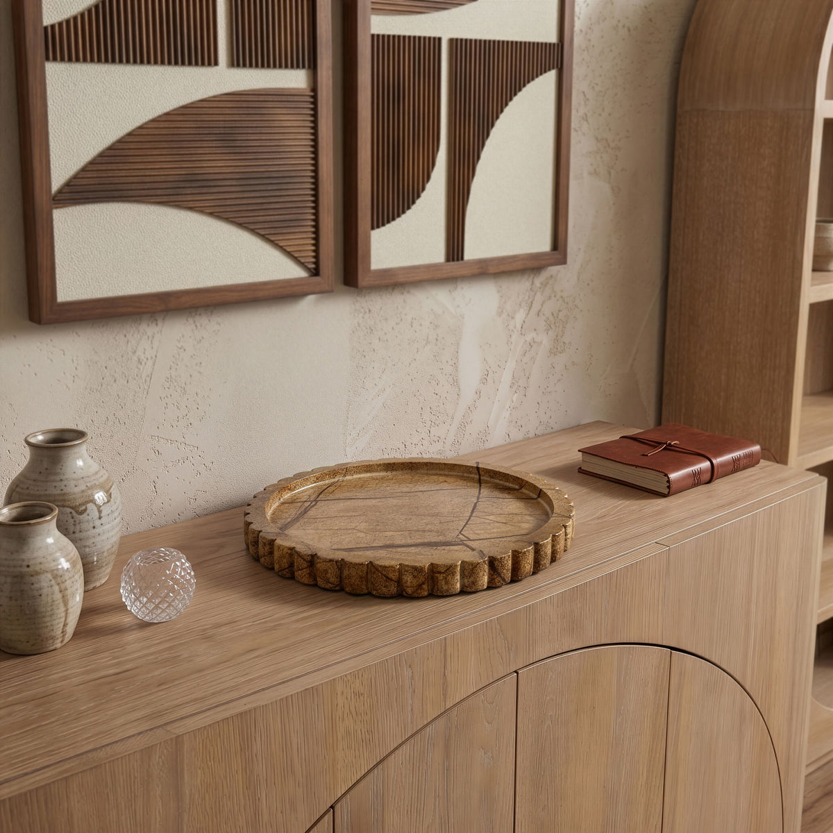 Round green marble tray on wooden shelf with scalloped outer rim