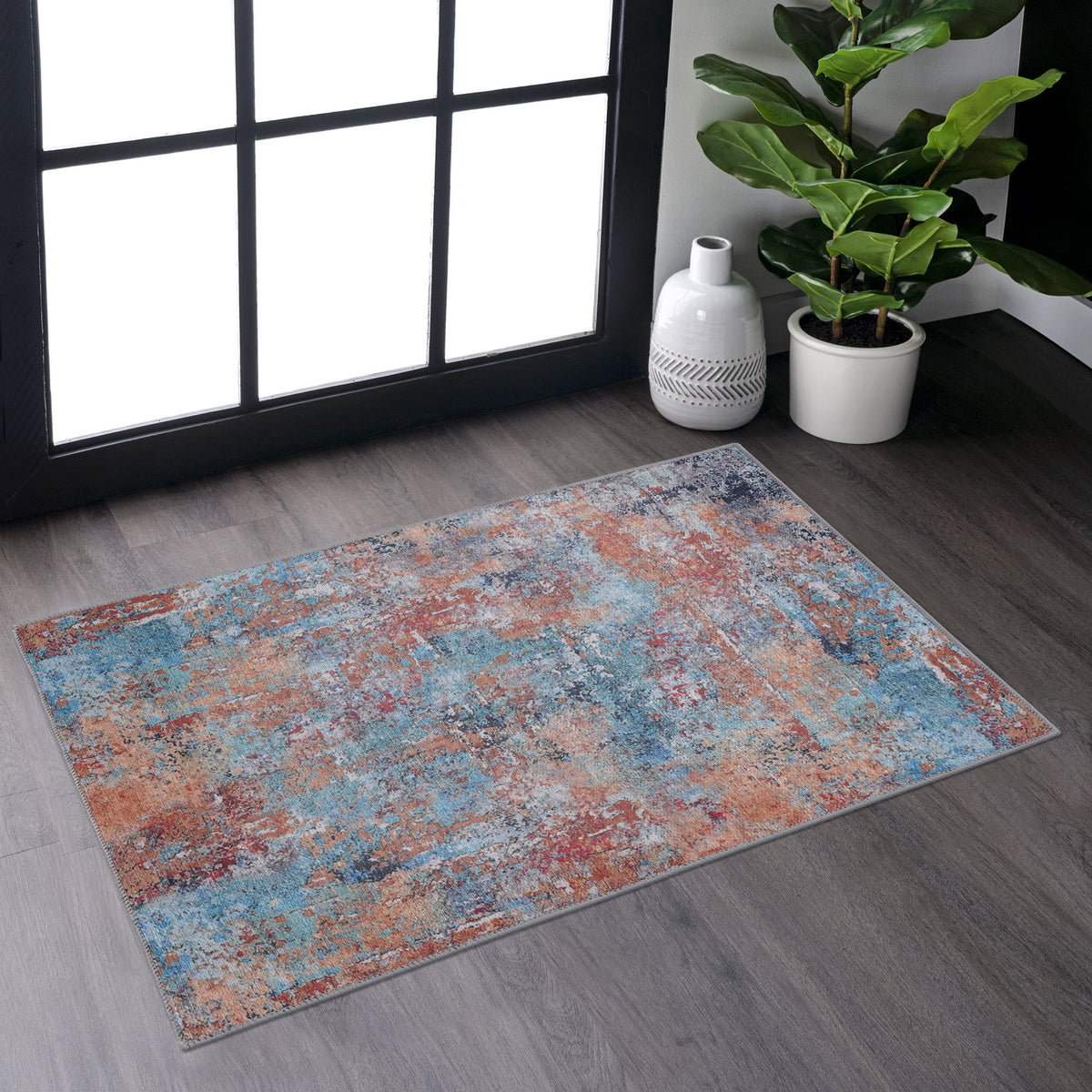 Machine-washable 2' x 3' area rug with abstract blue, orange, and gray pattern