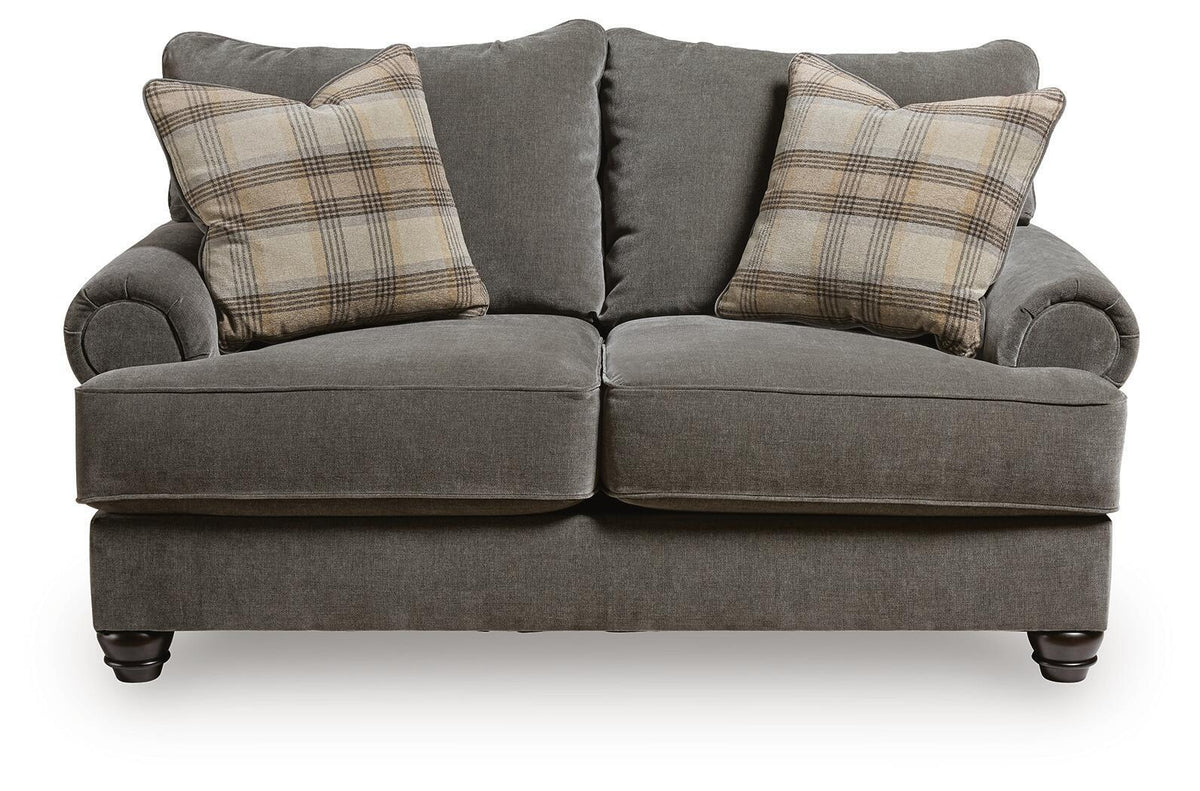 Gray fabric loveseat with side bolsters and plaid throw pillows