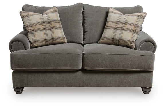 Gray fabric loveseat with side bolsters and plaid throw pillows