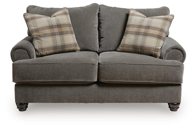Gray fabric loveseat with side bolsters and plaid throw pillows