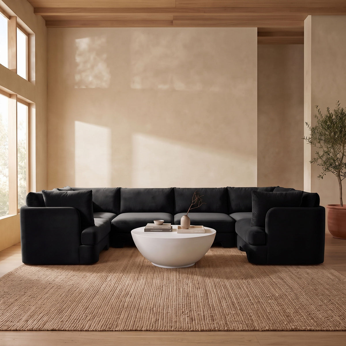 Black velvet U-shaped sectional sofa styled in a living room
