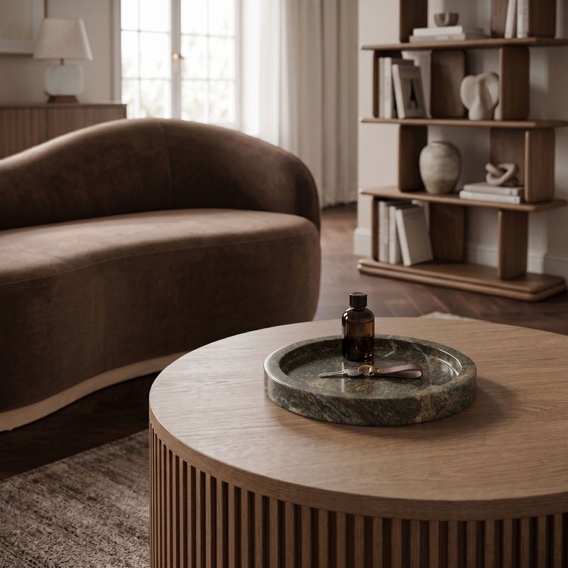 Round green marble tray on table with shallow basin and natural stone swirls