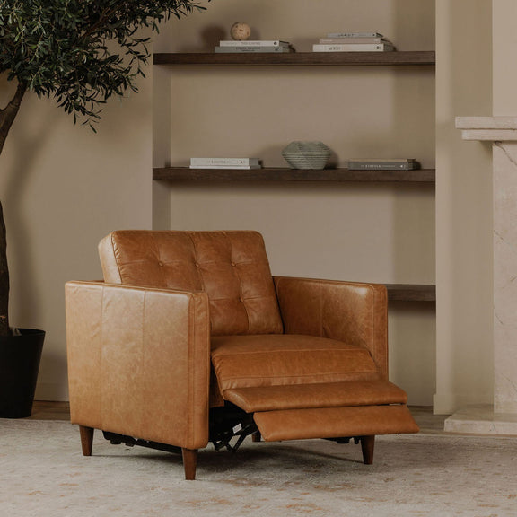 Tan leather recliner chair with extended footrest and visible power reclining mechanism