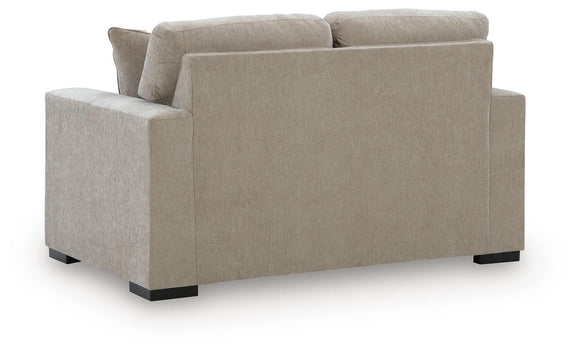 Beige upholstered loveseat with squared arms and dark block feet