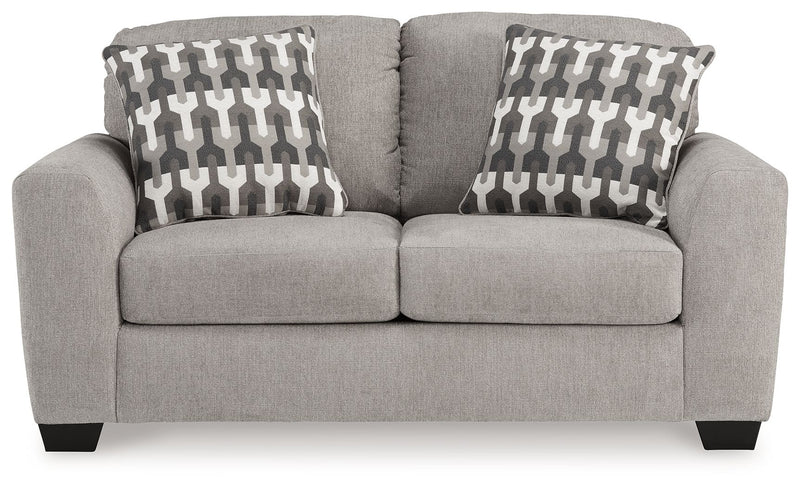 Gray upholstered loveseat with two back pillows in geometric pattern