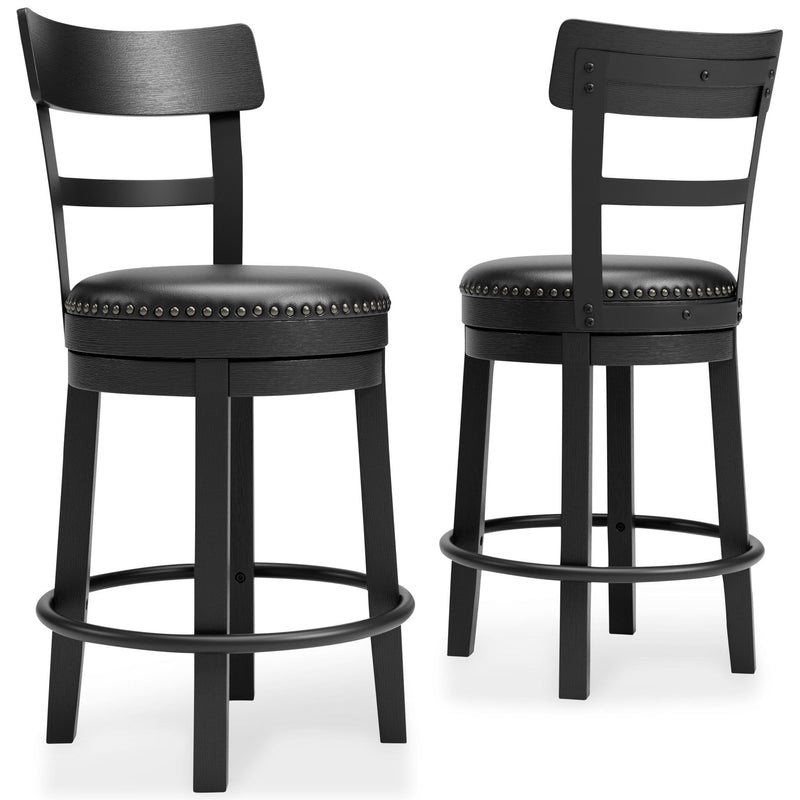 Pair of black swivel bar stools with studded round upholstered seats and curved footrest ring