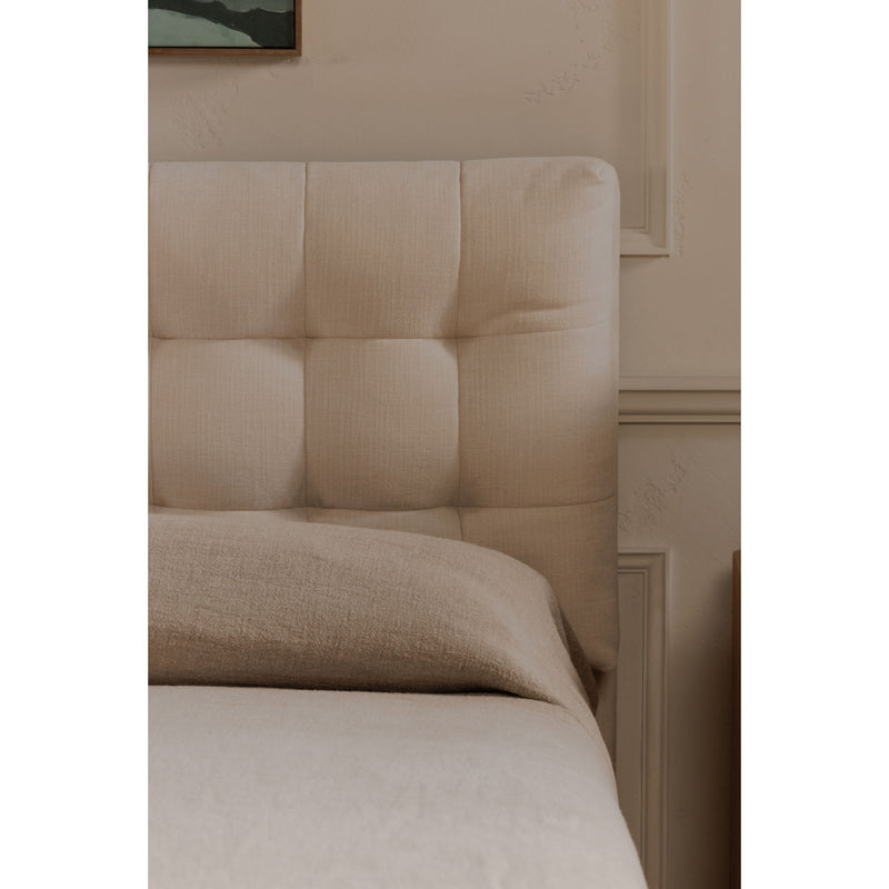 Cream upholstered king bed headboard with square tufting and padded top rail