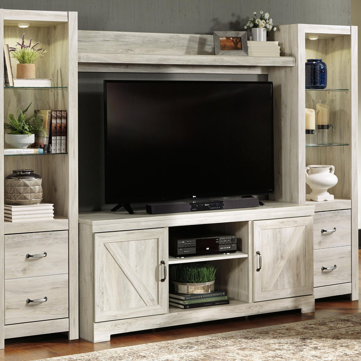 Light beige entertainment center with TV area and lower console with electric fireplace insert