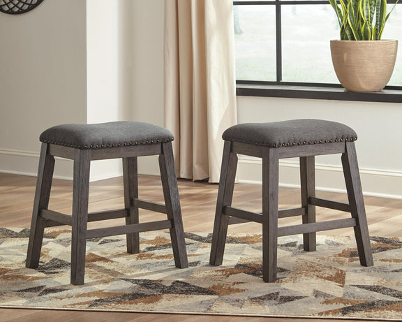 Gray upholstered bar stools with round seats and studded edges