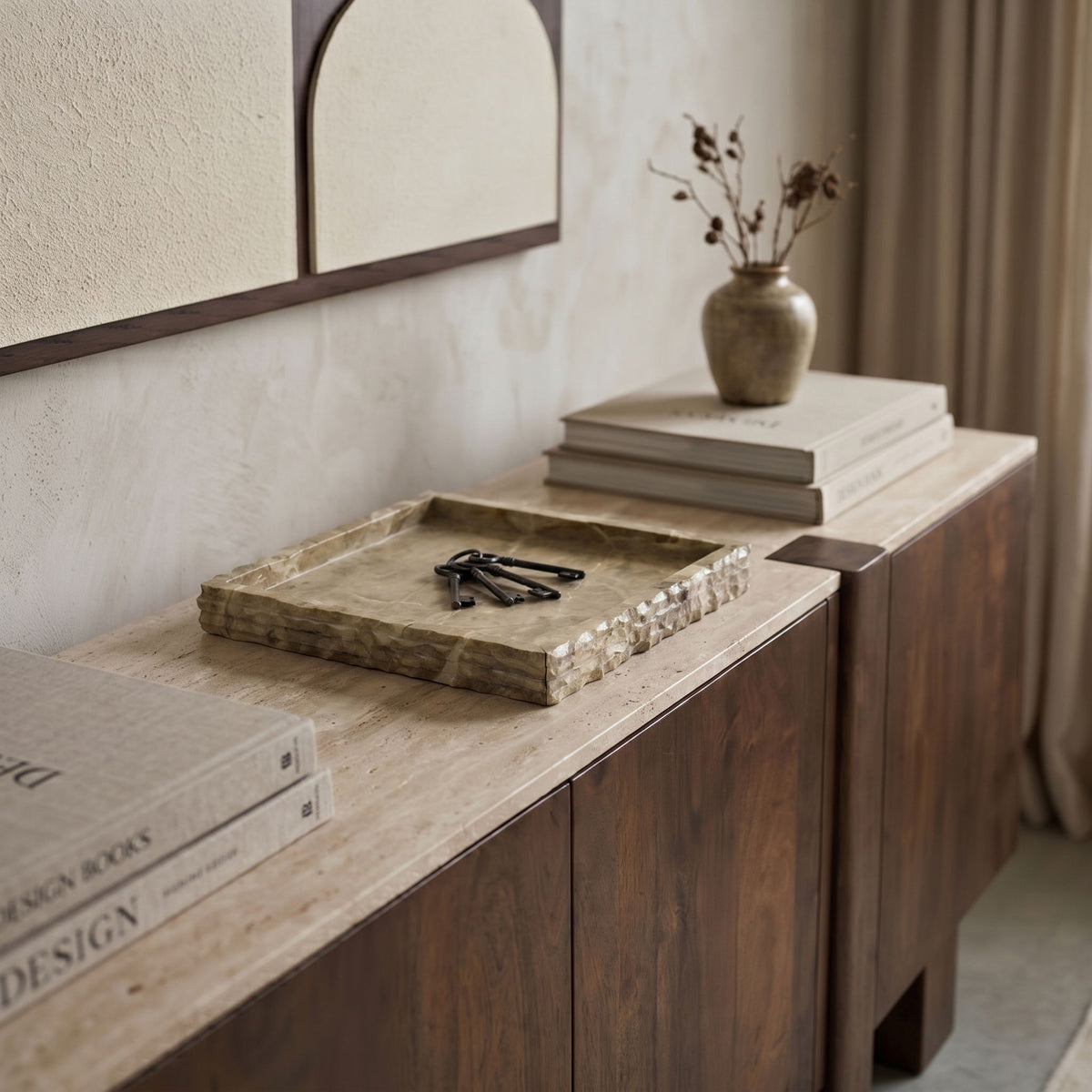 Beige marble tray on a countertop with natural mottling and veined square surface.