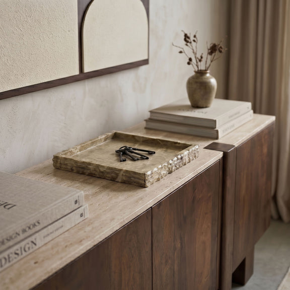 Beige marble tray on a countertop with natural mottling and veined square surface.