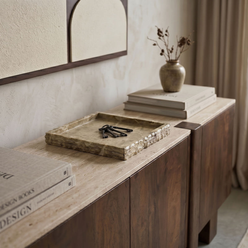 Beige marble tray on a countertop with natural mottling and veined square surface.