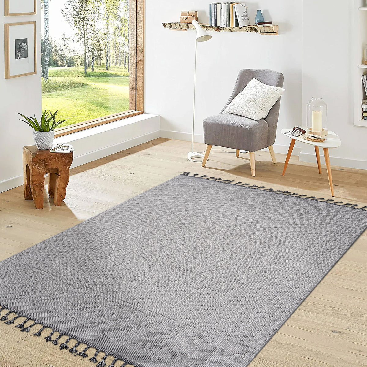 Light gray area rug with large medallion motif, geometric pattern, and tasseled edges