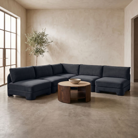 Dark blue armless velvet sectional sofa with deep seats and padded back cushions.