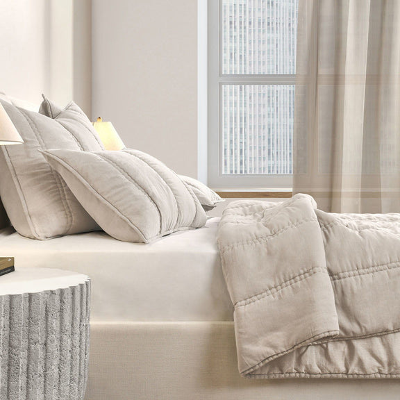 Cream quilt set corner view with quilted throw cover and matching pillows