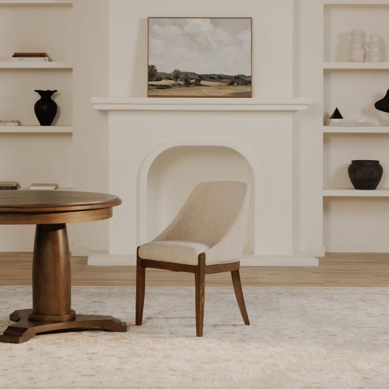 Upholstered beige dining chair with curved back and armrests, dark wood tapered legs