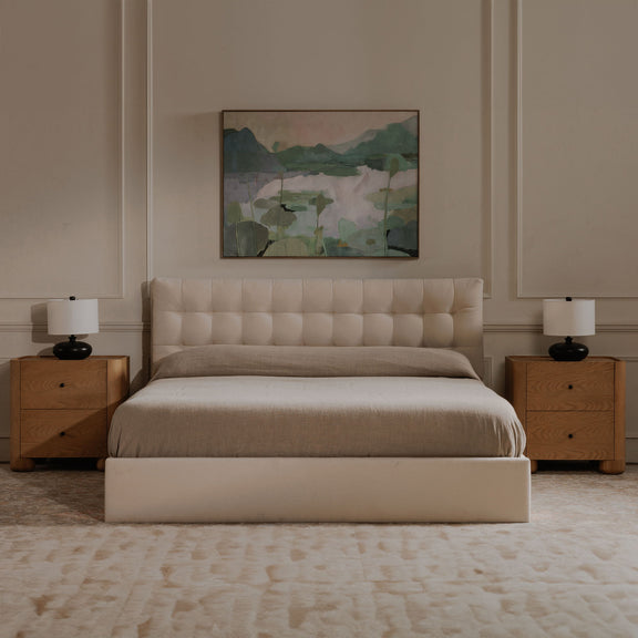 Cream king storage bed with tufted headboard, upholstered footboard, and cushioned rails