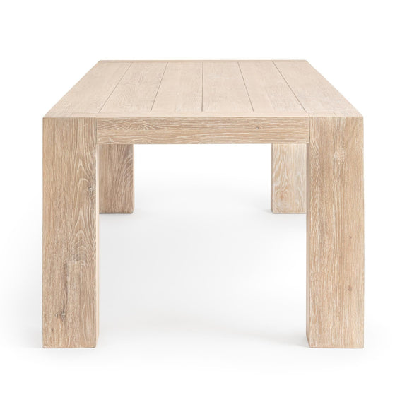 Light wood dining table with rectangular top opening and thick squared legs.
