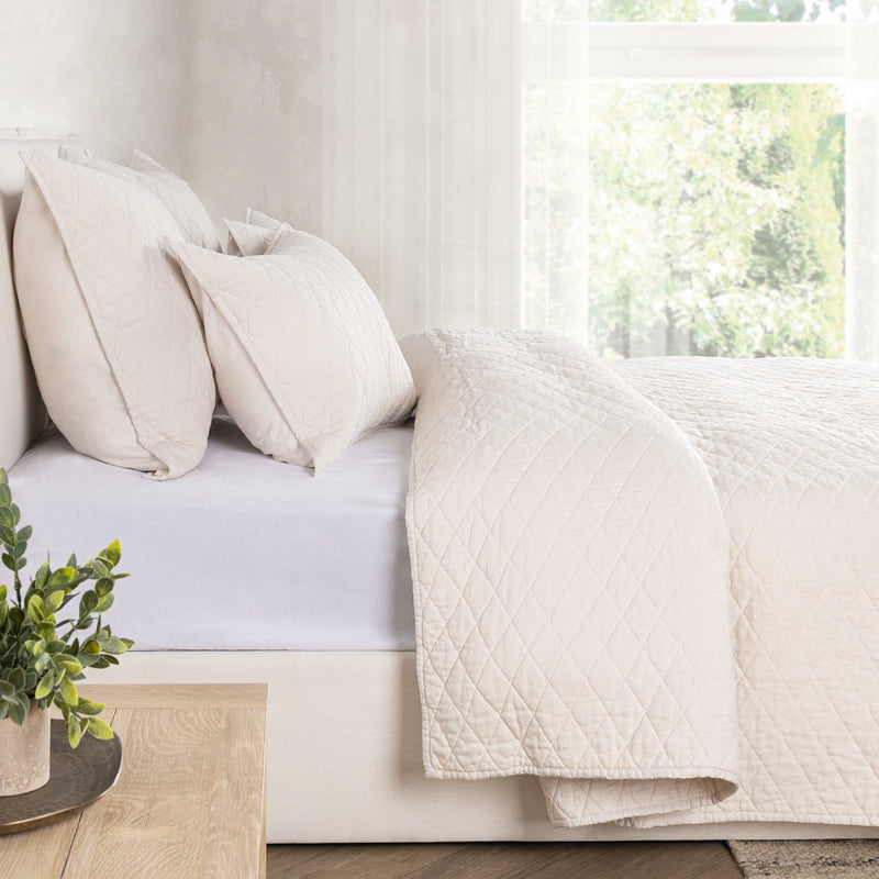 Ivory diamond-quilt wool throw quilt over a couch back and seat cushions.