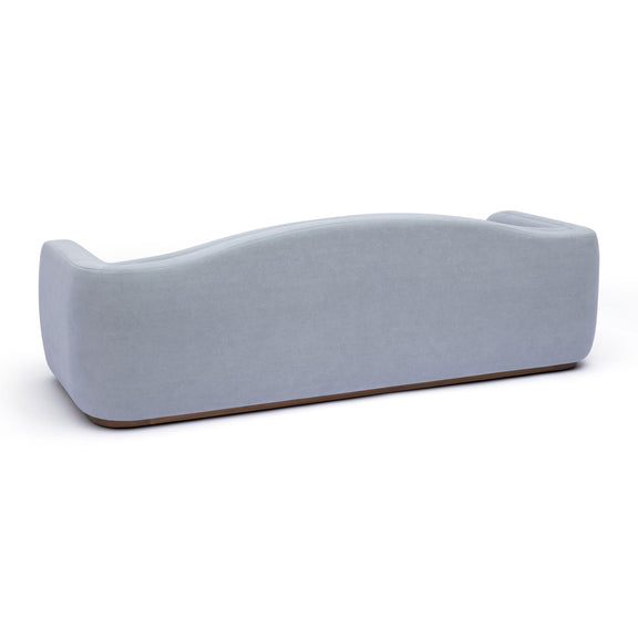 Light blue fabric sofa side view with rounded backrest and low base