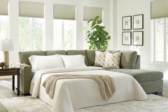 Green sleeper sectional sofa opened into bed with white striped bedding