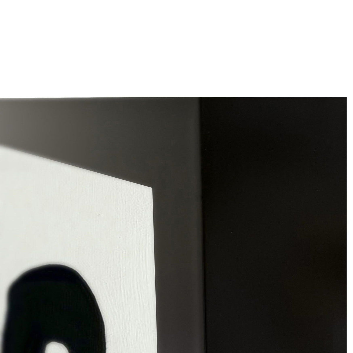 Close-up of black and white canvas wall art corner with bold painted strokes
