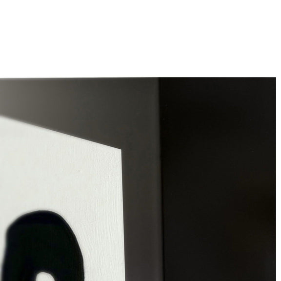 Close-up of black and white canvas wall art corner with bold painted strokes