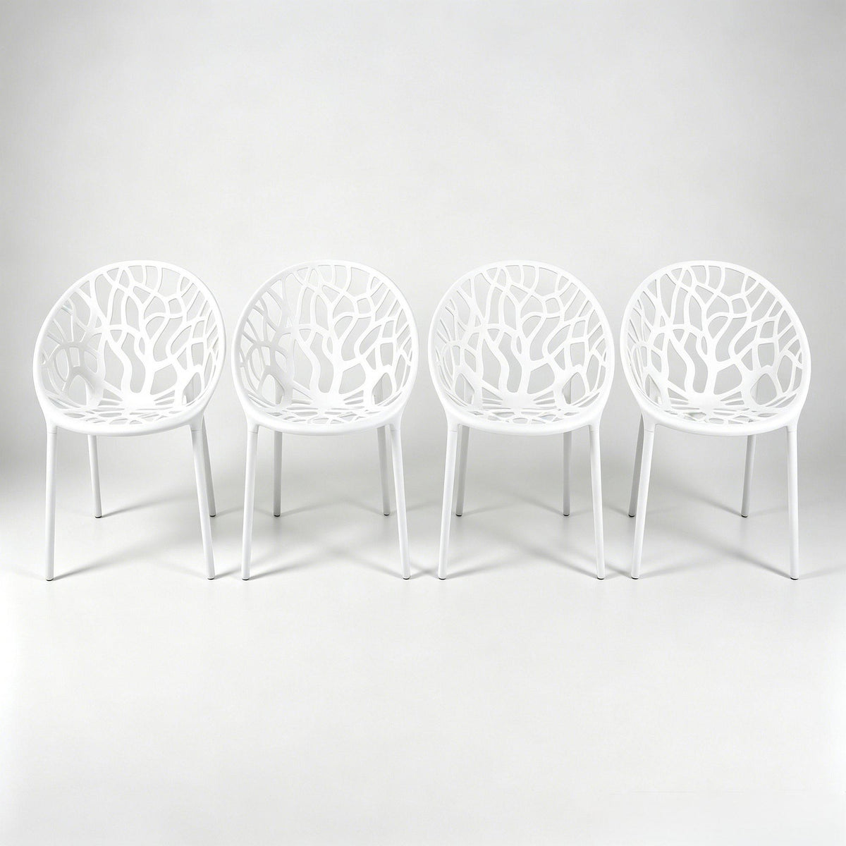 Set of 4 white dining chairs with cutout shell backs and slender legs