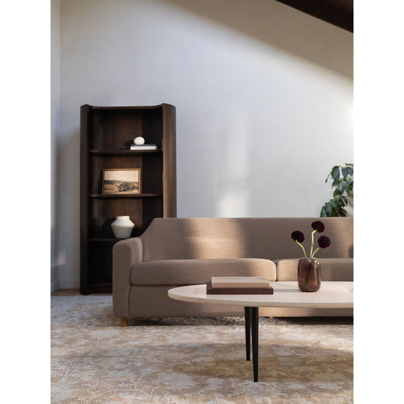 Soft brown upholstered sofa with low back and rounded armrests in a living room.
