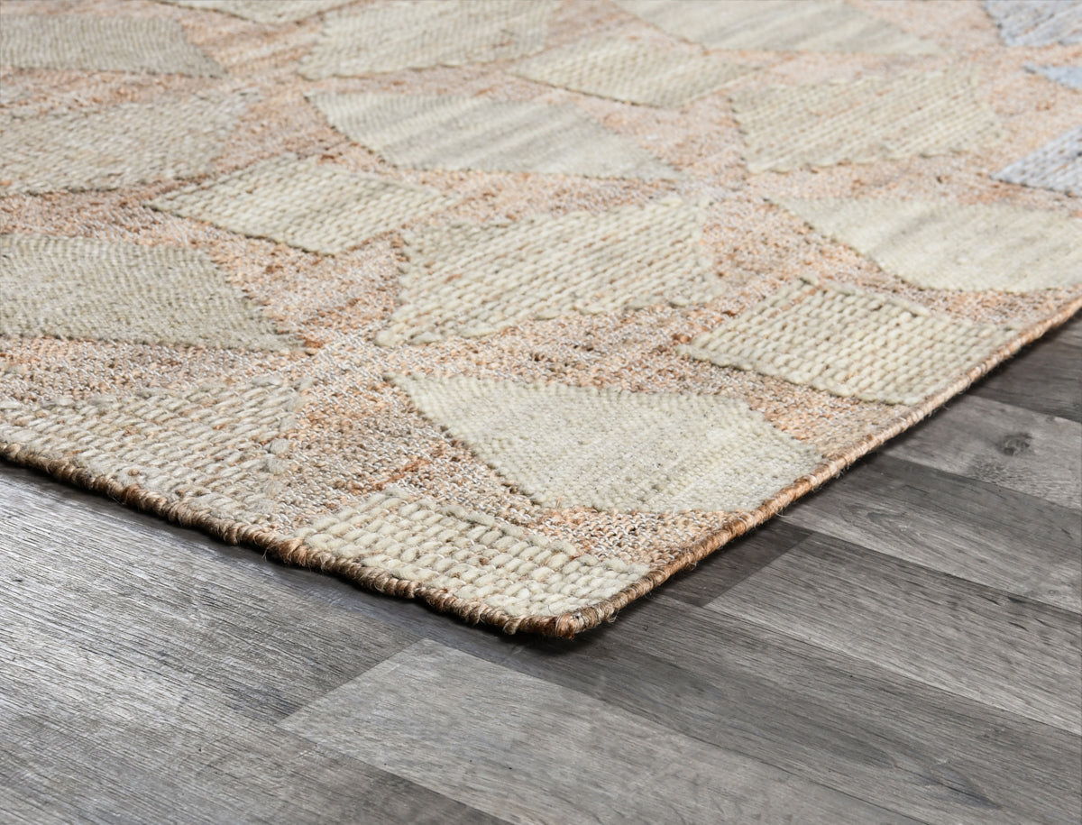 Flatweave rug corner close-up with beige weave and multicolor diamond-thread pattern