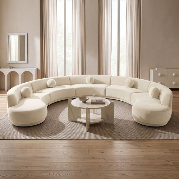 White velvet sectional sofa with rounded, button-tufted seat cushions in a room.