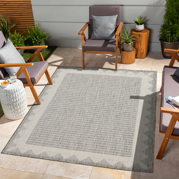 Gray striped area rug with zigzag border and geometric corner accents