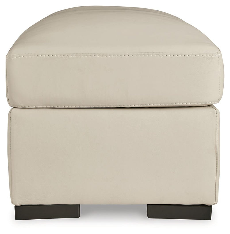 Almond ottoman with tufted-look lid seam and stitched upholstery on front panel