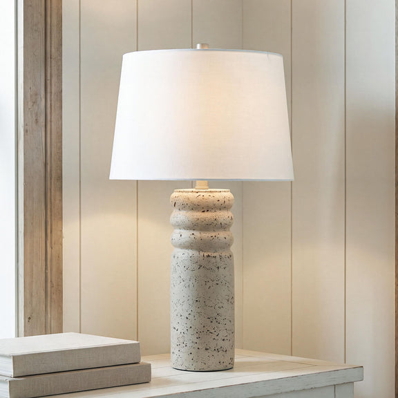 Beige speckled poly table lamp with white drum shade and metal stem