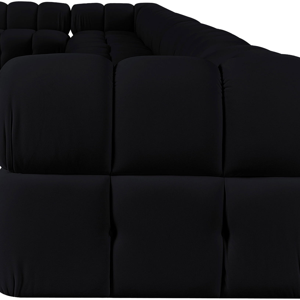 Black velvet L-shaped sectional sofa, close-up of tufted back cushions