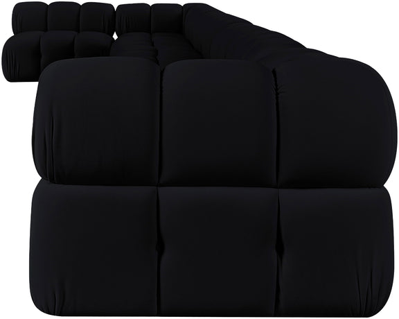 Black velvet L-shaped sectional sofa, close-up of tufted back cushions